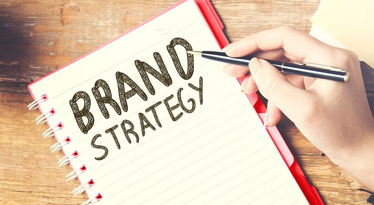 The words brand strategy written in a spiral notebook. CM2 Media blog on the basics of Brand Strategy for your business. Why Brand Strategy